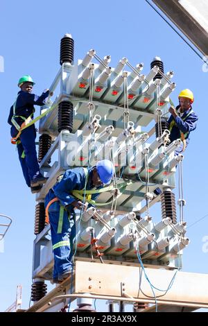 Electricians working on high voltage power lines Stock Photo