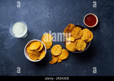 Mexican round-shaped nacho chips in bowls with hot chili salsa and a glass of beer Stock Photo