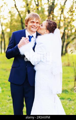 Photo of happy newlyweds outdoors. Beautiful young bride and groom in love. Stock Photo
