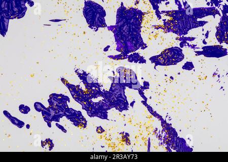 On a white background, blue splashes of acrylic paint with gold sparkles. Stock Photo