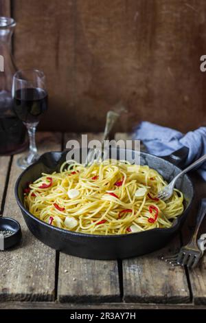 Spaghetti aglio, olio e peperoncino, blach pepper, red wine (Italy) Stock Photo