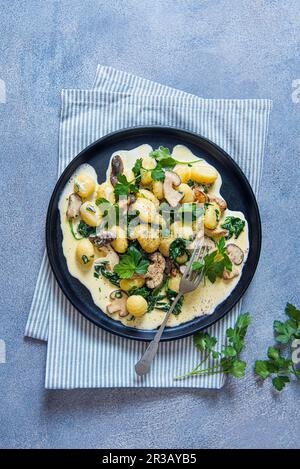 Potato gnocchi with creamy garlic mushrooms sauce and spinach Stock Photo