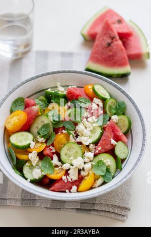 Salad from watermelon, cucumber, yellow tomatoes, mint and feta Stock Photo