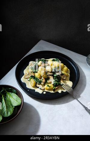 Potato gnocchi with creamy garlic mushrooms suce and spinach Stock Photo