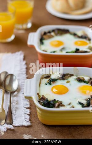 Mushroom, spinach and egg bake, orange juice, bread roll Stock Photo