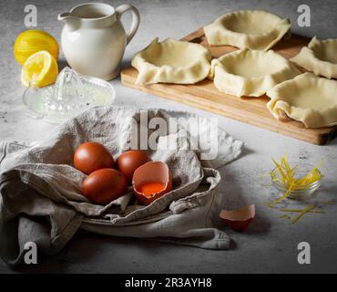 Pastry tart cases uncooked with brown eggs and lemon Stock Photo