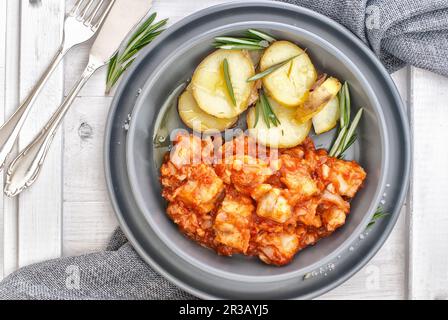 Baccala alla livornese - oven roast cod in tomato sauce with potatoes Stock Photo