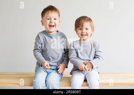 Two little kids. Portrait of a happy little children - boy and girl. Beautiful kids against a white Stock Photo
