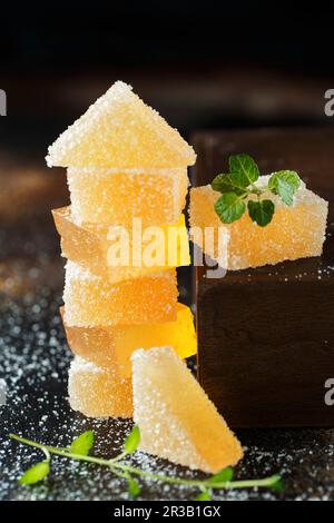 Fruit jelly candies. Homemade orange, pear or apricot candies in sugar on dark background. Fruit che Stock Photo