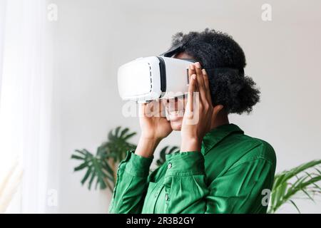 Smiling woman wearing virtual reality simulator Stock Photo