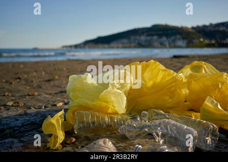 Plastic bags and bottles littered at beach Stock Photo