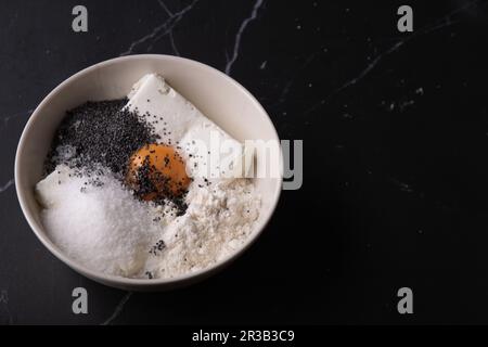 photo flour, cottage cheese, poppy seed, egg yolk in a deep bowl Stock Photo