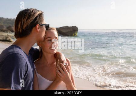 Man kissing woman on forehead at beach Stock Photo