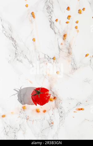 A splattered tomato on a marble surface Stock Photo