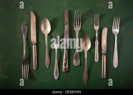 Vintage cutlery on a green surface Stock Photo