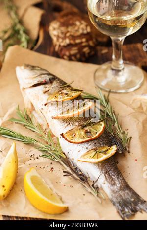 Oven-baked Sea bass with lemon and herbs. Seabass fish, baked entirely Stock Photo