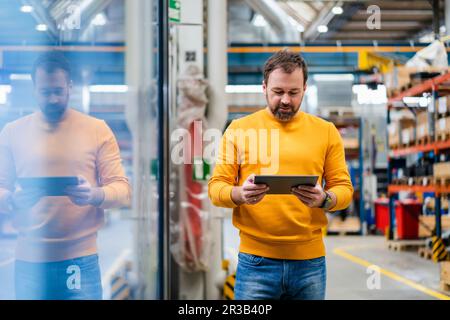 Mature manager using tablet PC in industry Stock Photo