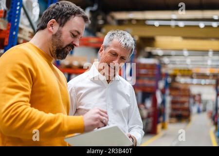 Businessmen having discussion over tablet PC Stock Photo