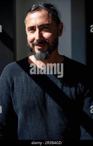 Smiling man wearing black longsleeve shirt at cafe Stock Photo