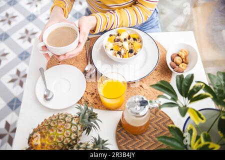 Woman having healthy breakfast at table Stock Photo