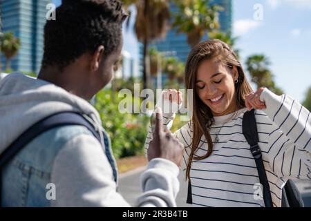 Young man looking at happy friend dancing at park Stock Photo