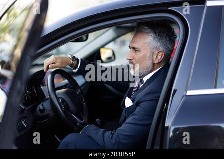 Businessman wearing suit sitting in car Stock Photo