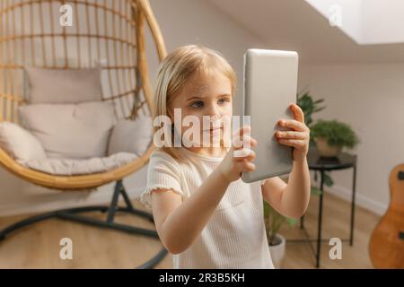 Girl holding tablet PC at home Stock Photo