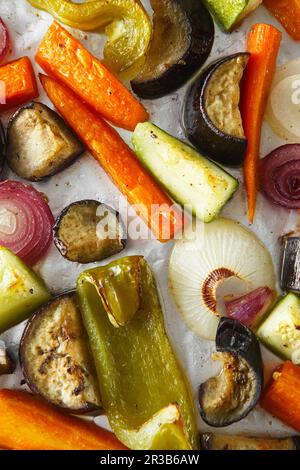 Roasted vegetables mix on baking tray, food above. Vegan food background Stock Photo