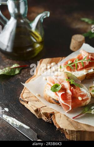 Traditional parma cured ham antipasto. Bruschetta set with Parma Ham and Parmesan Cheese. Small sand Stock Photo