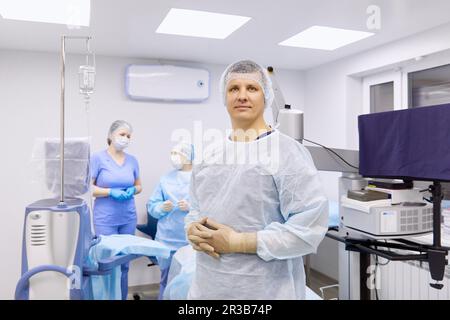 Surgeon with colleagues in illuminated operating room Stock Photo