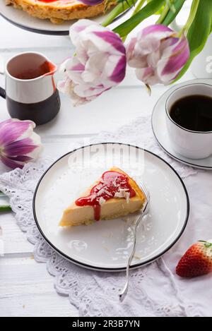 Vegan cheesecake with strawberry sauce and white, grated rice milk chocolate Stock Photo