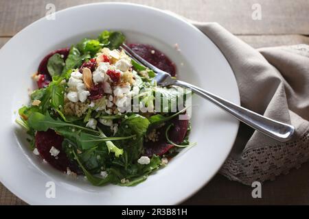 Arugula salad with beets, goat cheese, toasted almonds and quinoa Stock Photo