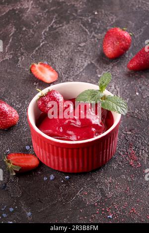 Strawberry sorbet in red bowl and fresh berries Stock Photo