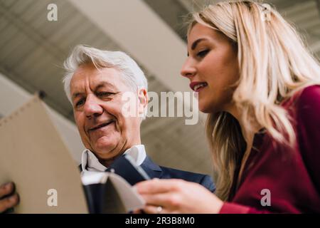 Business partners reviewing documents in industry Stock Photo