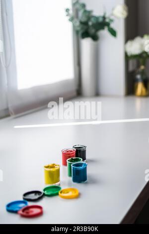jars of gouache on windowsill - art painting and drawing lessons Stock Photo
