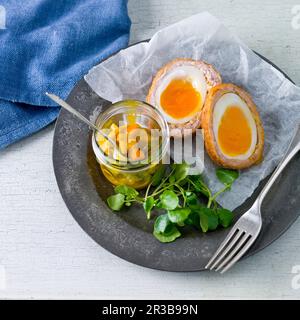 Scotch eggs with a cauliflower pickle and watercress Stock Photo