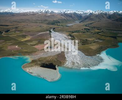 An aerial view of the blue glacial lake - Lake Tekapo, with mountains and blue sky backgrounds, in South Island, New Zealand Stock Photo