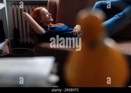 Smiling woman relaxing on sofa Stock Photo