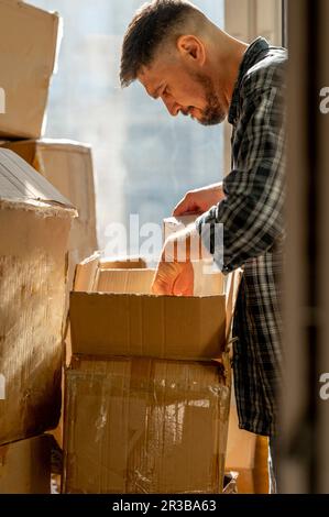 Man packing cardboard boxes at home Stock Photo