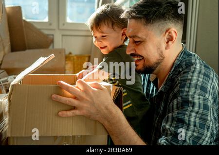 Father and son packing cardboard boxes at home Stock Photo