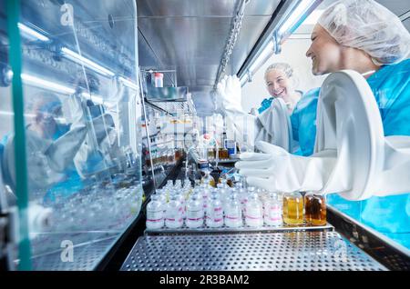 Chemical workers giving high-five inside microbiological safety cabinet Stock Photo