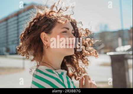 Smiling young woman with curly hair Stock Photo