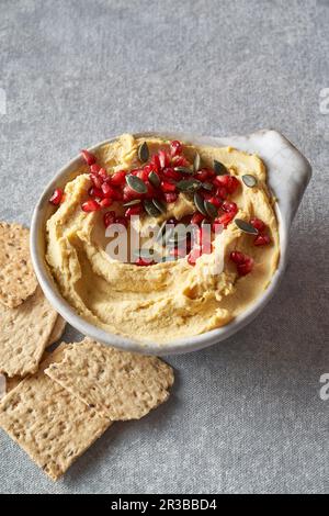 hummus with pomegranate and pumpkin seeds Stock Photo