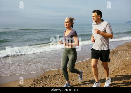 Mature couple jogging together at sunny day Stock Photo