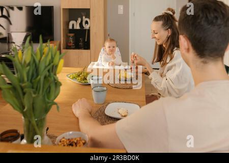 Family eating meal together at dinner table Stock Photo