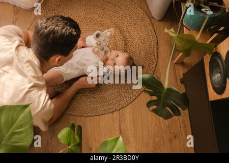 Father playing with daughter on floor at home Stock Photo