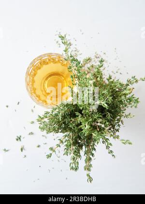 Thyme tea in a glass next to fresh thyme Stock Photo