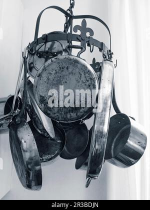 Old pots and pans on a hanging rack in a kitchen Stock Photo