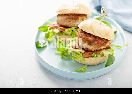 Turkey burgers with avocado, lettuce and bacon Stock Photo