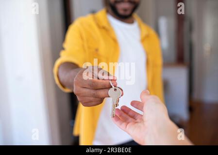 Real estate agent giving house keys to man Stock Photo